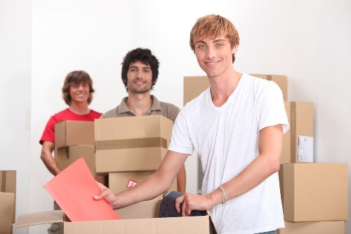 Professional movers carrying boxes for an urgent Soho relocation